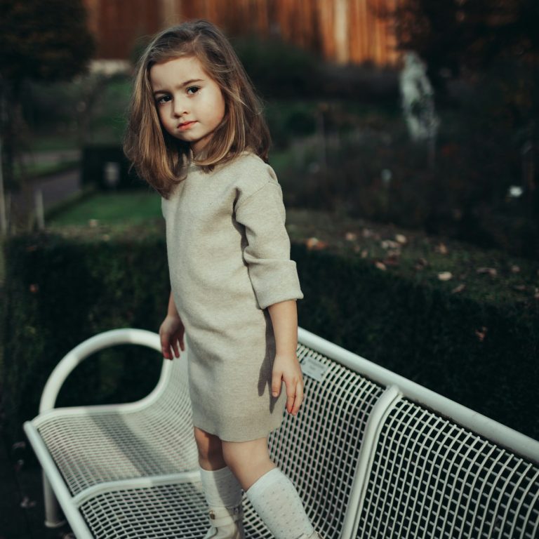 A girl in a soft oatmeal knit dress